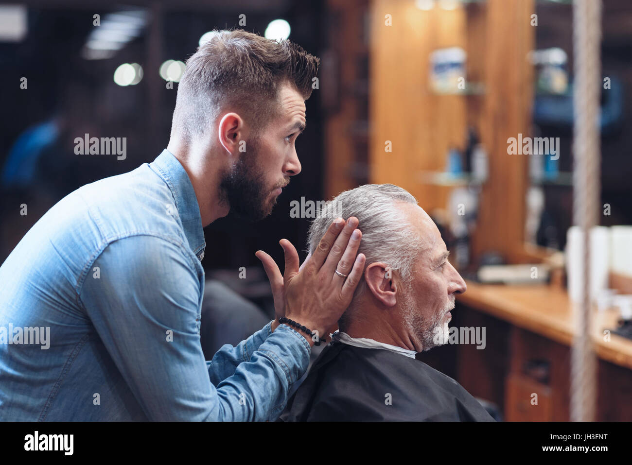 Bel barbiere professionale della modellazione di un'acconciatura Foto Stock