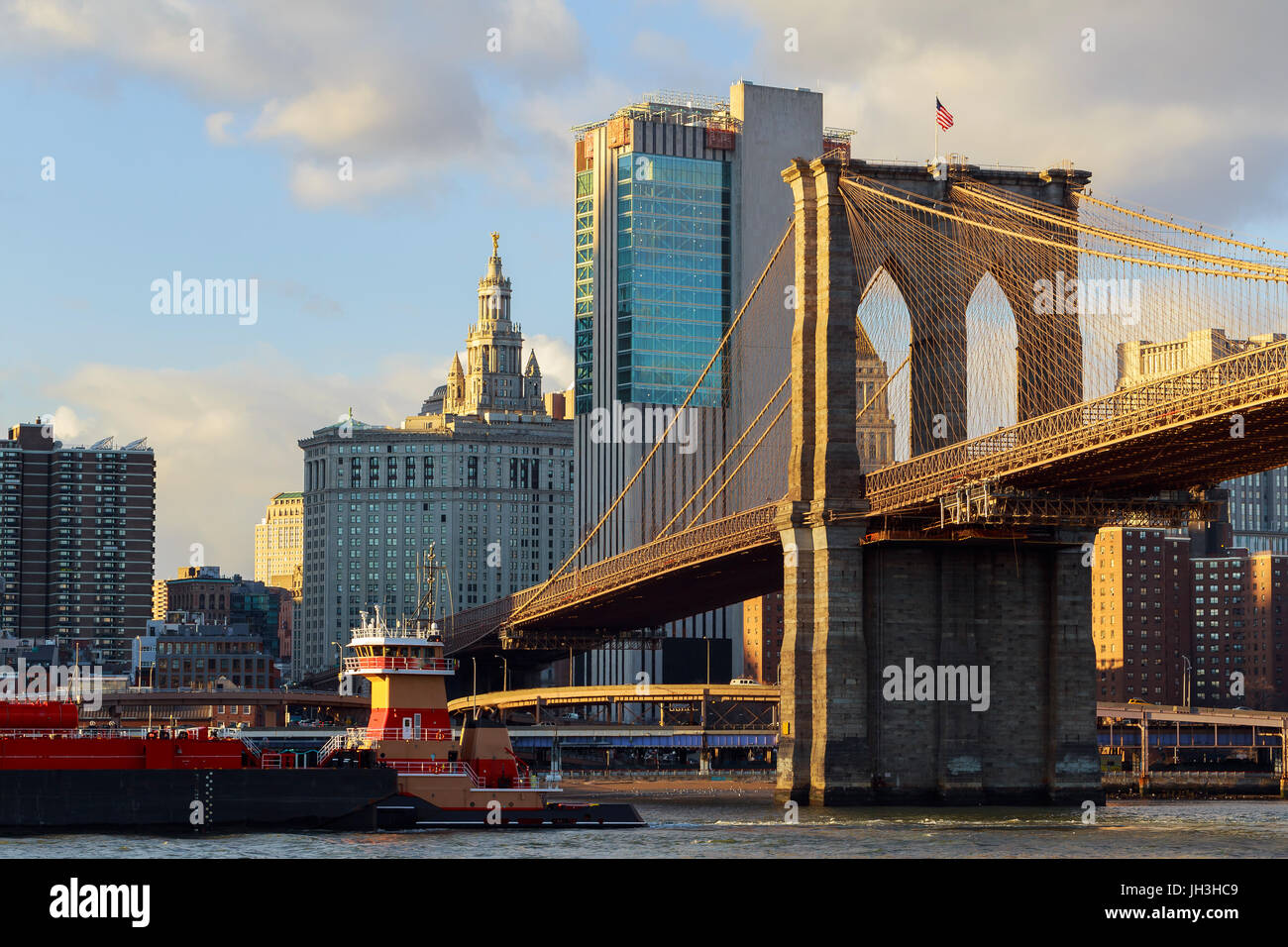 Il Ponte di Brooklyn si erge contro un cielo blu centro di grattacieli di Manhattan Foto Stock