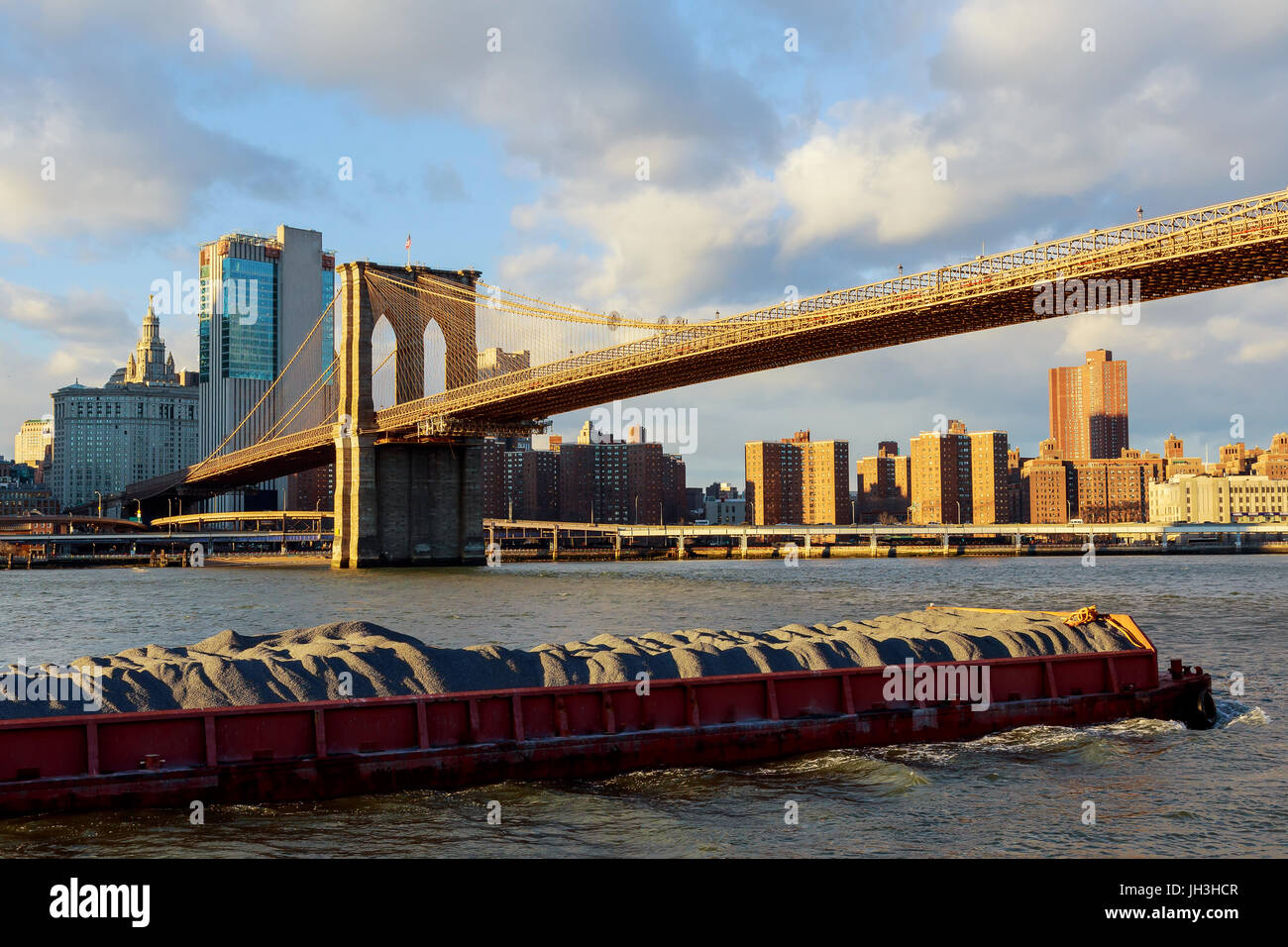 La chiatta galleggianti lungo il fiume Hudson in background del Ponte di Brooklyn il Ponte di Brooklyn con la parte inferiore di Manhattan in background nuovo Yo Foto Stock