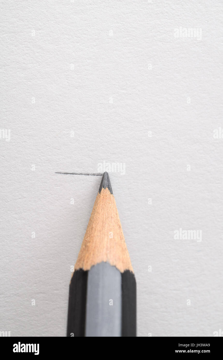 Una matita di grafite, il disegno di una linea orizzontale sul libro bianco. Copia spazio sopra. Foto Stock