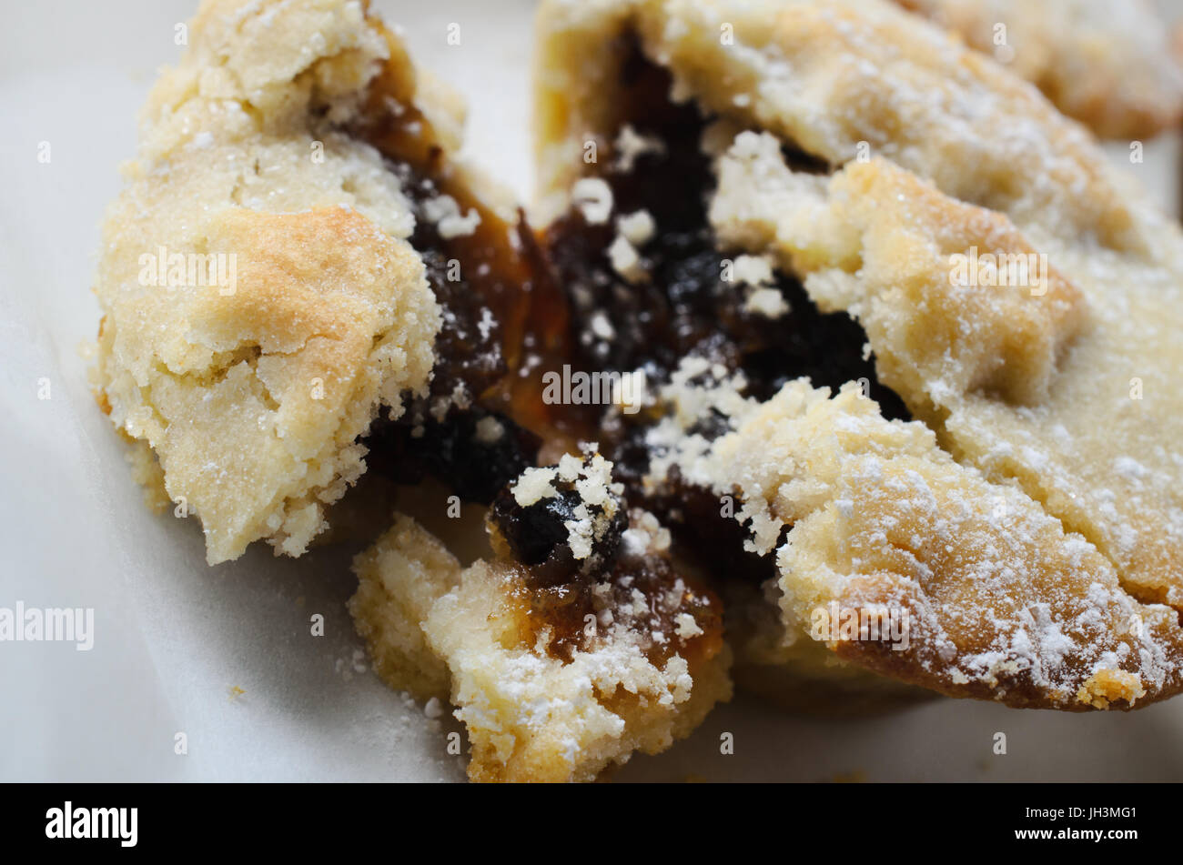 In prossimità di una pasta frolla friabile Natale tritare la torta con rottura della pasticceria aperta per esporre il riempimento. Foto Stock