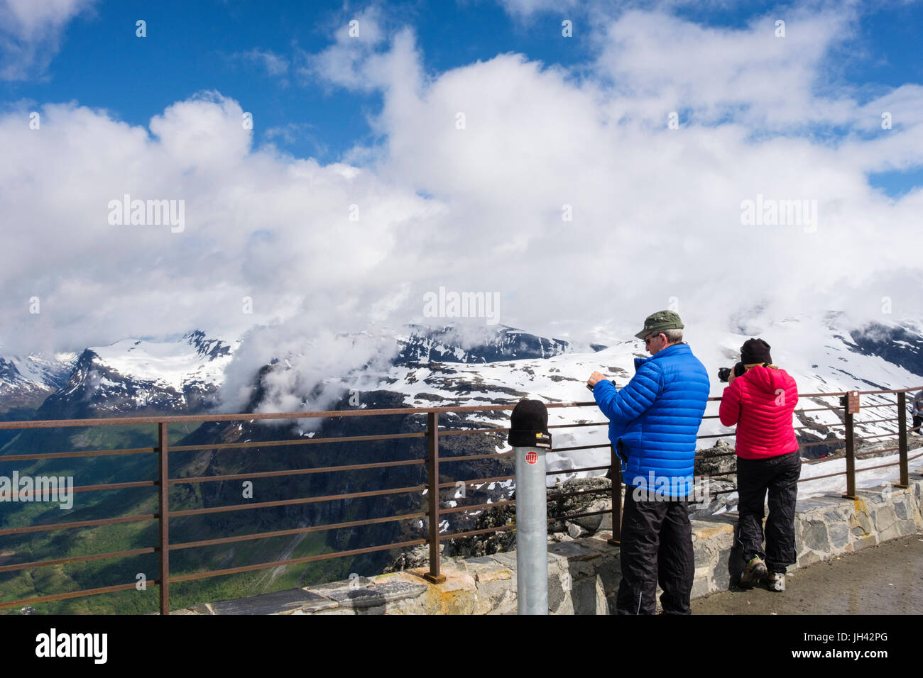 I turisti in cerca di vista panoramica dalla piattaforma di visualizzazione Dalsnibba sulla montagna che si affaccia Geirangerfjorden. Geiranger Sunnmøre Møre og Romsdal Norvegia Foto Stock
