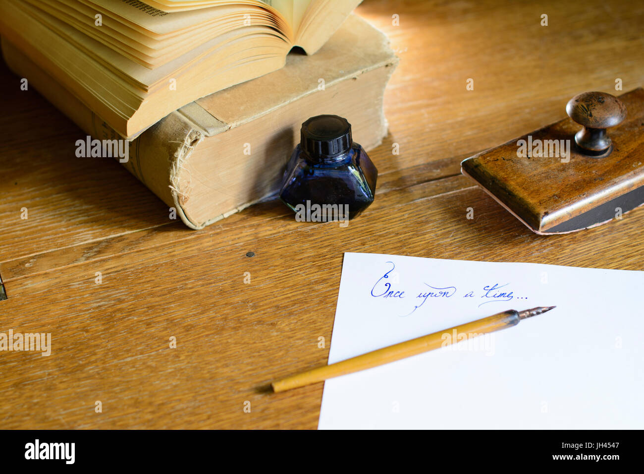 La frase "Una volta" splendidamente scritta a mano su un foglio di carta, circondato con un vecchio fermo. Foto Stock