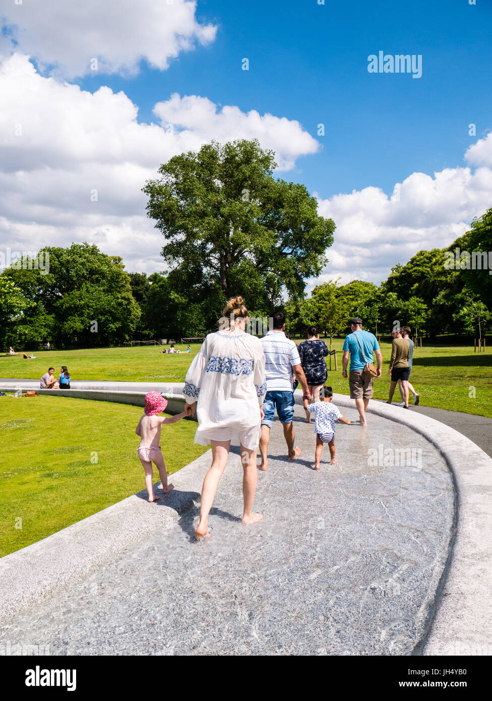 Per coloro che godono di sole, il Princess Diana Memorial Fountain, Hyde Park, Londra, Inghilterra, Regno Unito, GB. Foto Stock
