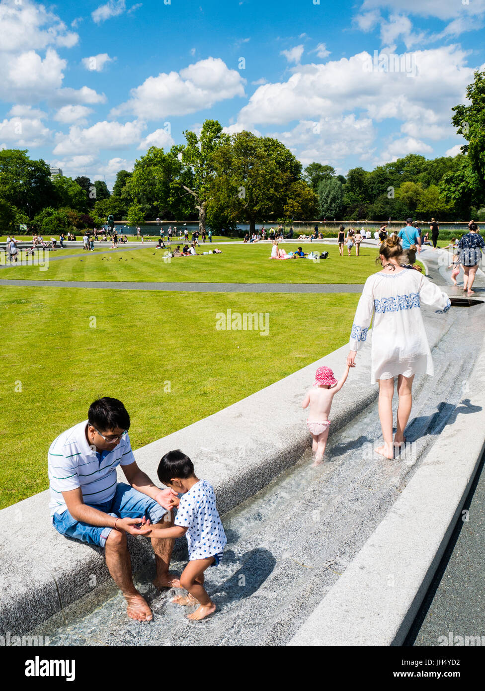 Per coloro che godono di sole, il Princess Diana Memorial Fountain, Hyde Park, Londra, Inghilterra, Regno Unito,GB. Foto Stock