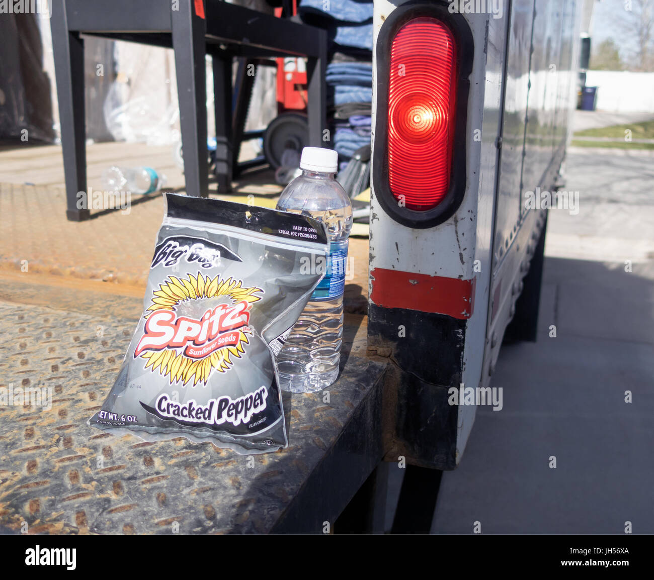 Un sacco di semi di girasole e una bottiglia di acqua seduto su un carrello mobile rampa. Foto Stock