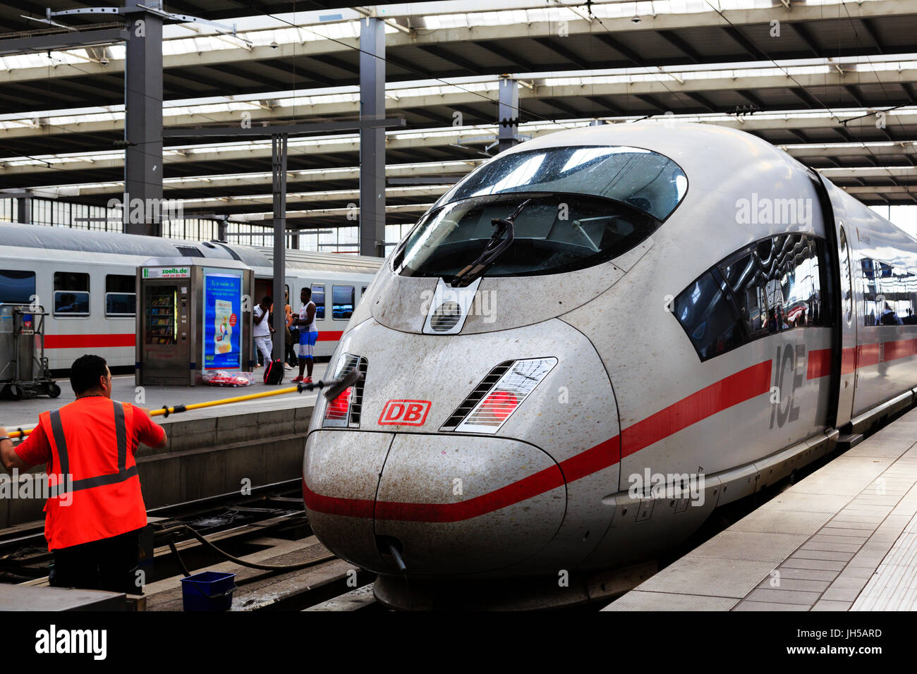 Deuthes Bundesbahn lavoratore la pulizia della parte anteriore di una alta velocità ICE (Inter City Express) treno motore in munich hauptbahnhof, Monaco di Baviera, Germania Foto Stock