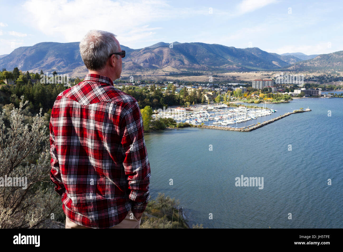 Uomo che guarda la città di Penticton da un punto di vista affacciato sul Lago Okanagan situato nell'Okanagan Valley, British Columbia, Canada. Foto Stock