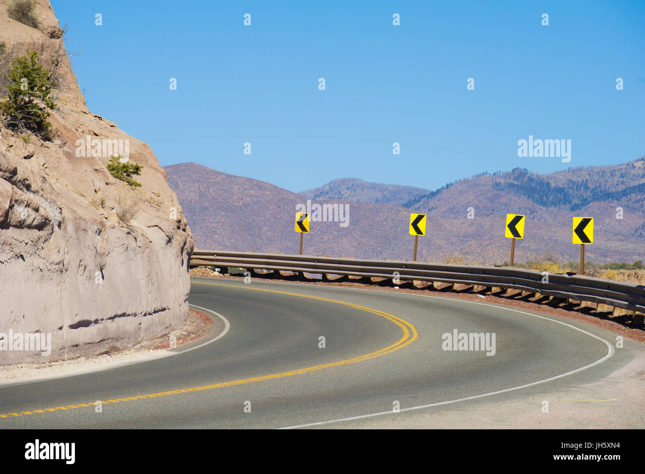 Autostrada curva in montagna girando a sinistra sulla strada a Los Alamos, Nuovo Messico. Foto Stock
