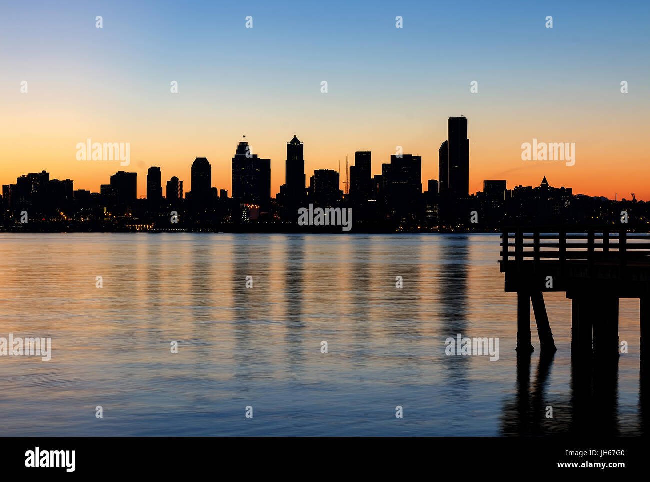 Seattle Washington skyline della città silhouette dal molo Alki Beach durante il bagliore arancione sunrise Foto Stock