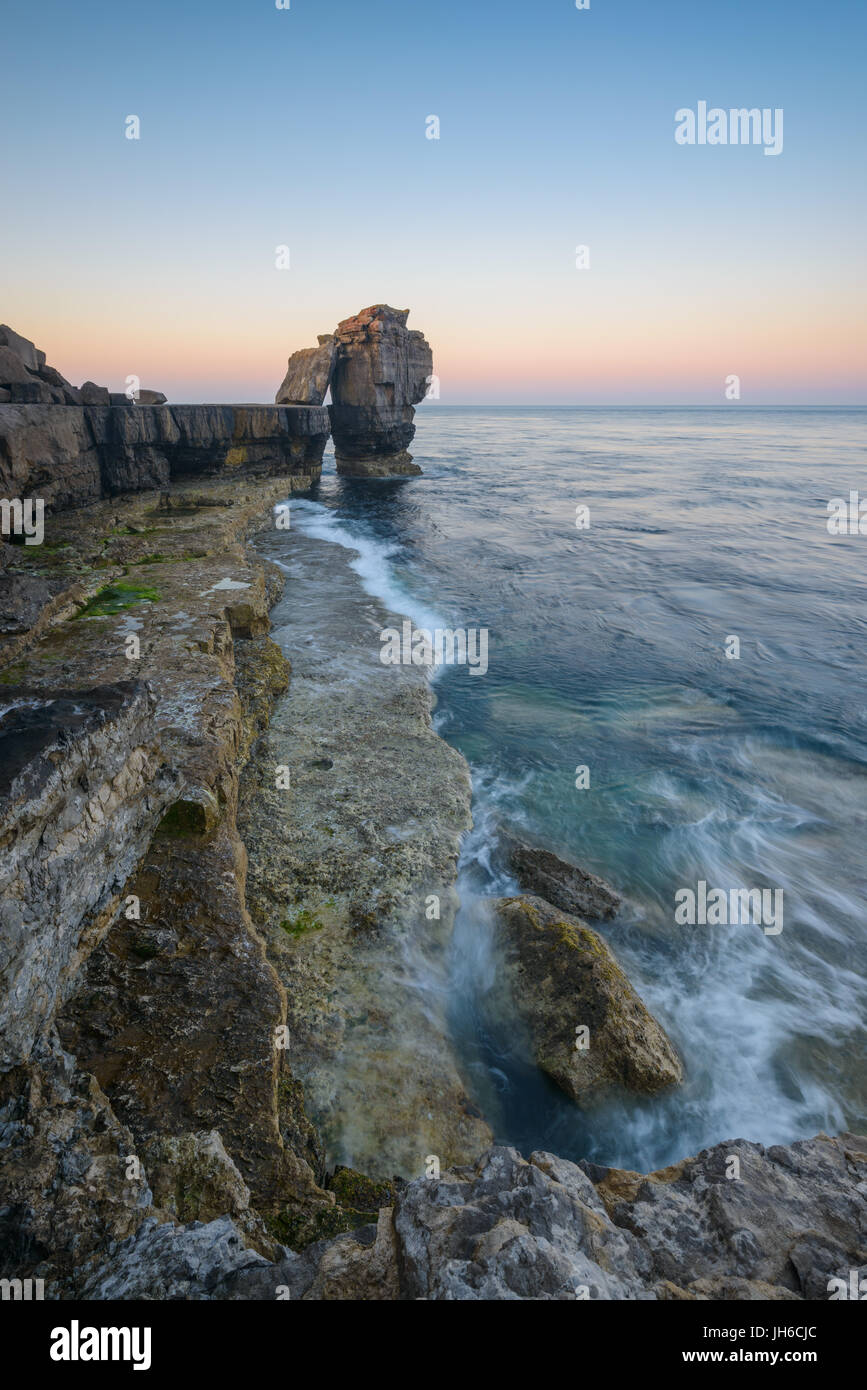 Twilight rompe su il celeberrimo pulpito Rock al Portland Bill su una chiara mattina di primavera lungo la Jurassic Coast in Dorset, England, Regno Unito Foto Stock