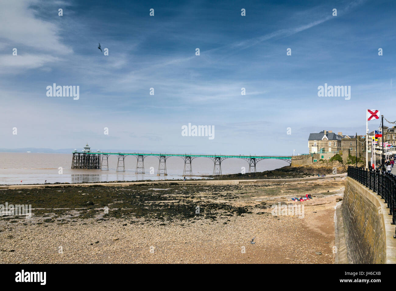 Bandiere di diverse nazioni sul lungomare che si affaccia il restaurato molo vittoriano di Clevedon sul Canale di Bristol, North Somerset, Inghilterra, Regno Unito Foto Stock