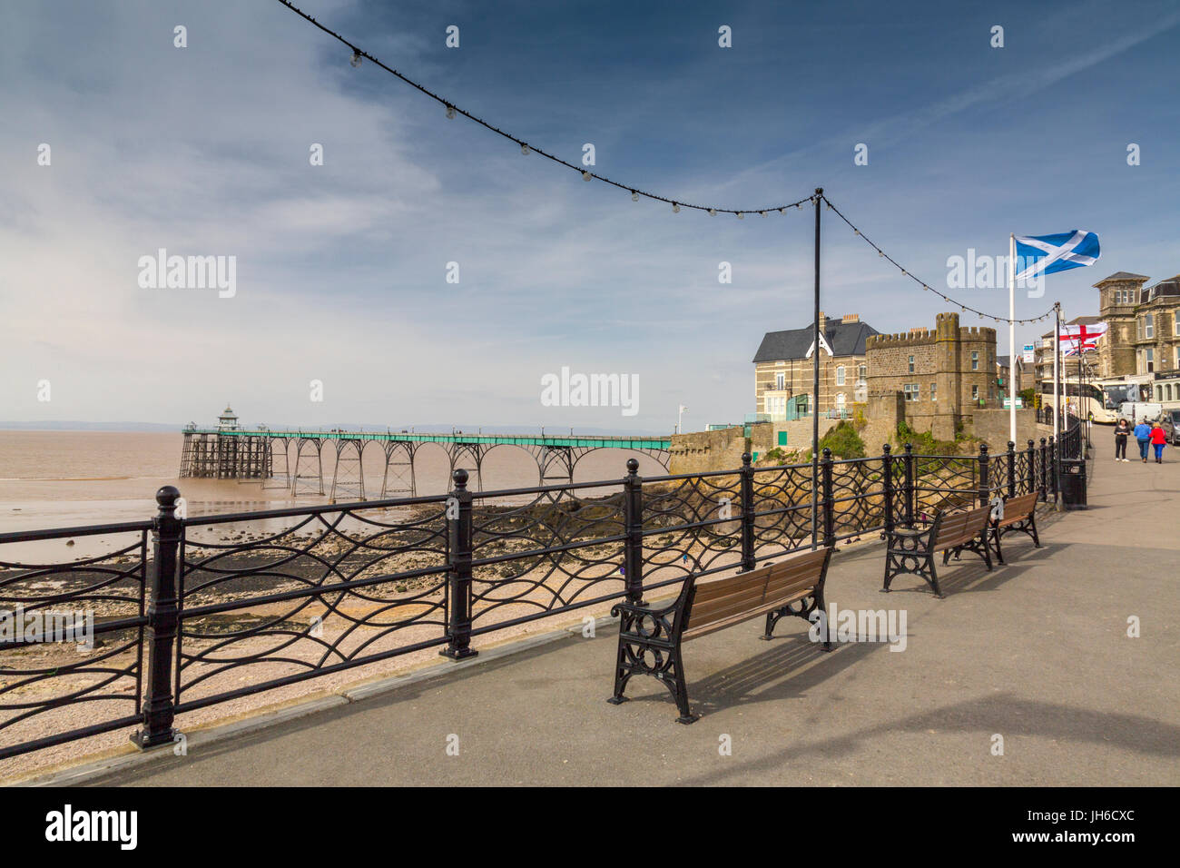 Bandiere di diverse nazioni sul lungomare che si affaccia il restaurato molo vittoriano di Clevedon sul Canale di Bristol, North Somerset, Inghilterra, Regno Unito Foto Stock