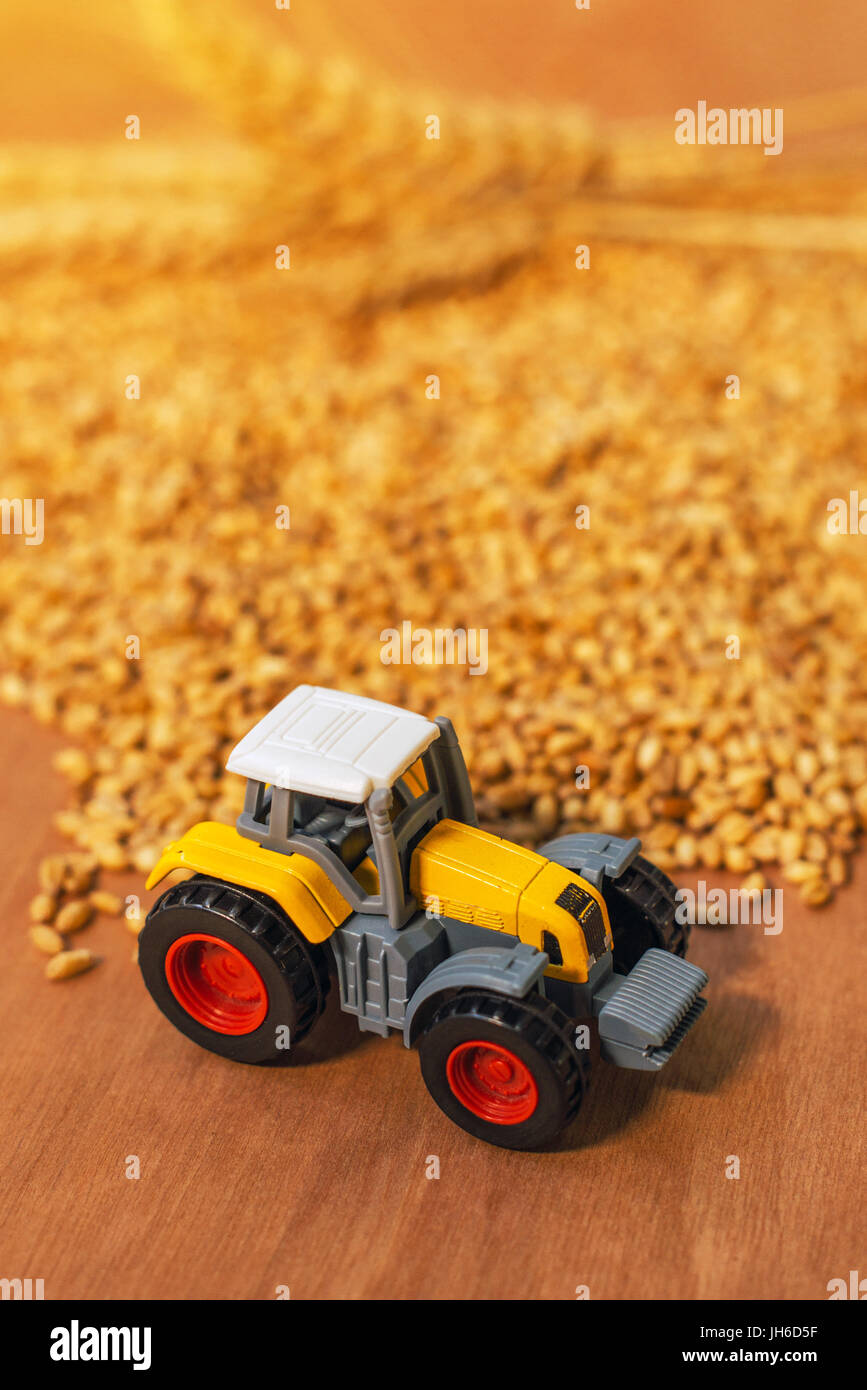 Trattore agricolo giocattolo e raccolte chicchi di grano, il fuoco selettivo Foto Stock