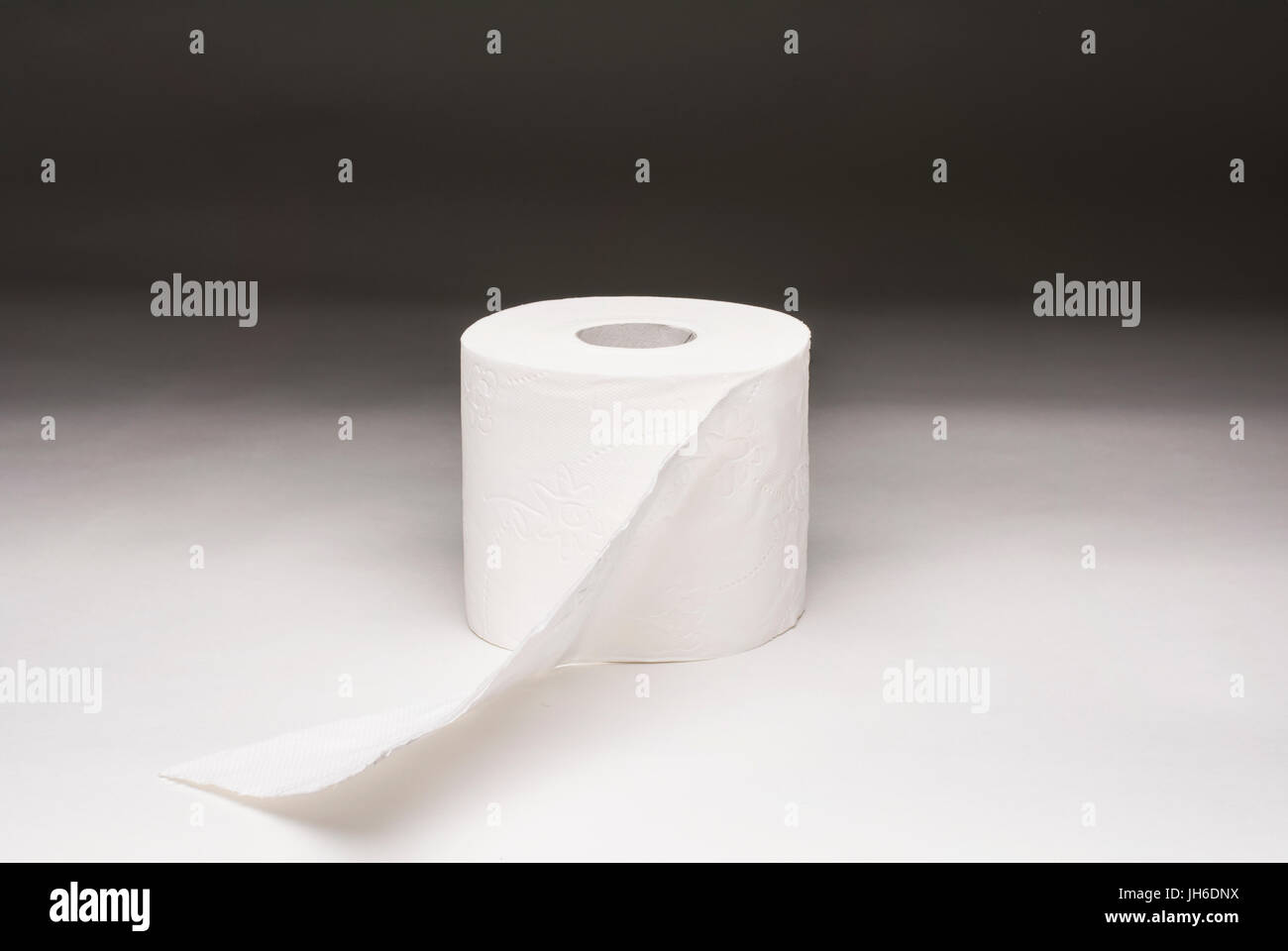 Un rotolo di carta igienica fotografato su un sfondo graduata Foto Stock