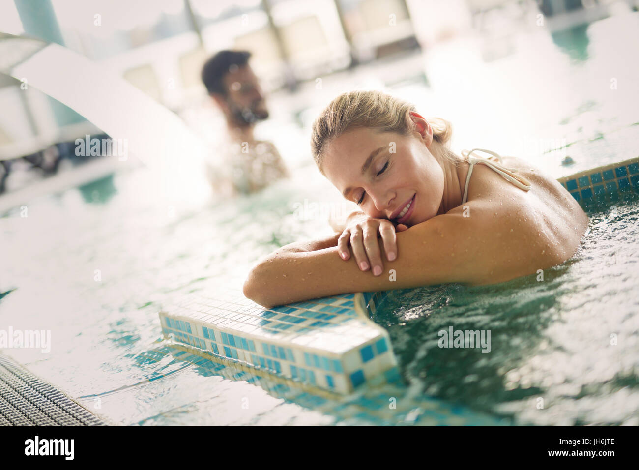 Bella donna attraente godersi il tempo in piscina Foto Stock