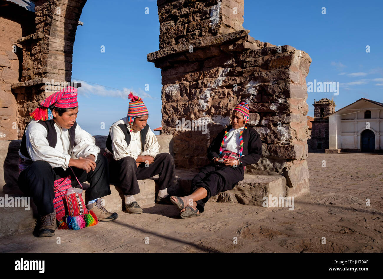 TAQUILE ISLAND, Perù - circa ottobre 2015: Uomini avente una conversazione in Taquile isola la piazza principale, nel Lago Titicaca, Perù. Foto Stock