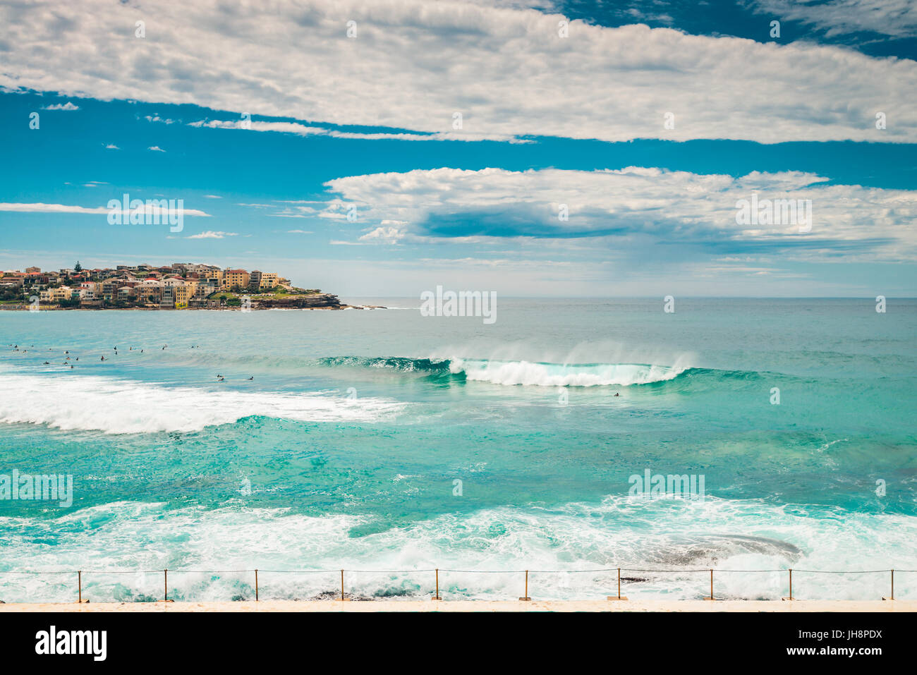 La spiaggia di Bondi surfers cattura onde su un luminoso giorno. La spiaggia di Bondi è uno dei luoghi più famosi del mondo per il surf in Australia Foto Stock