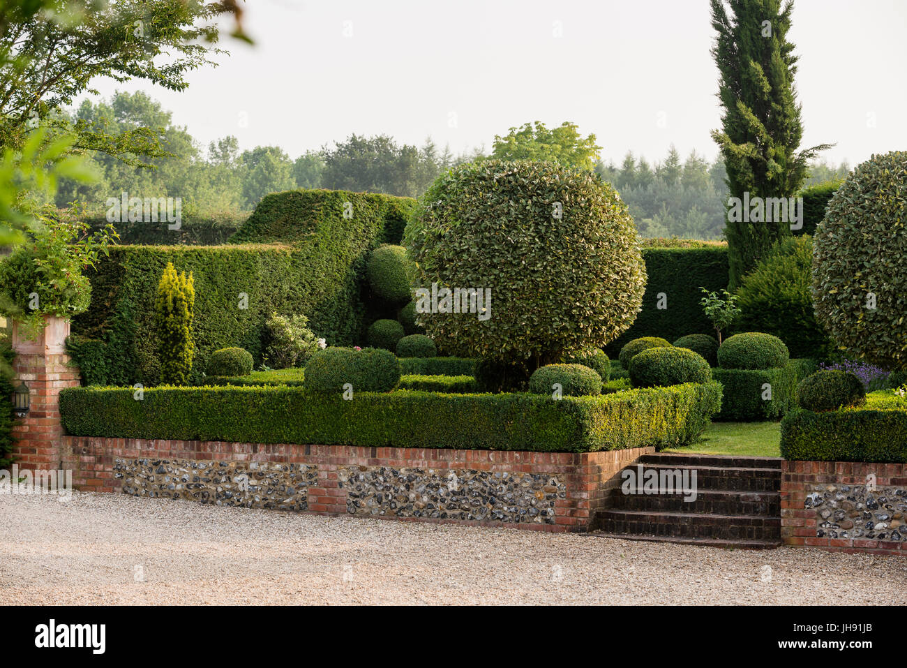 Muro di mattoni e scale in hedge garden Foto Stock