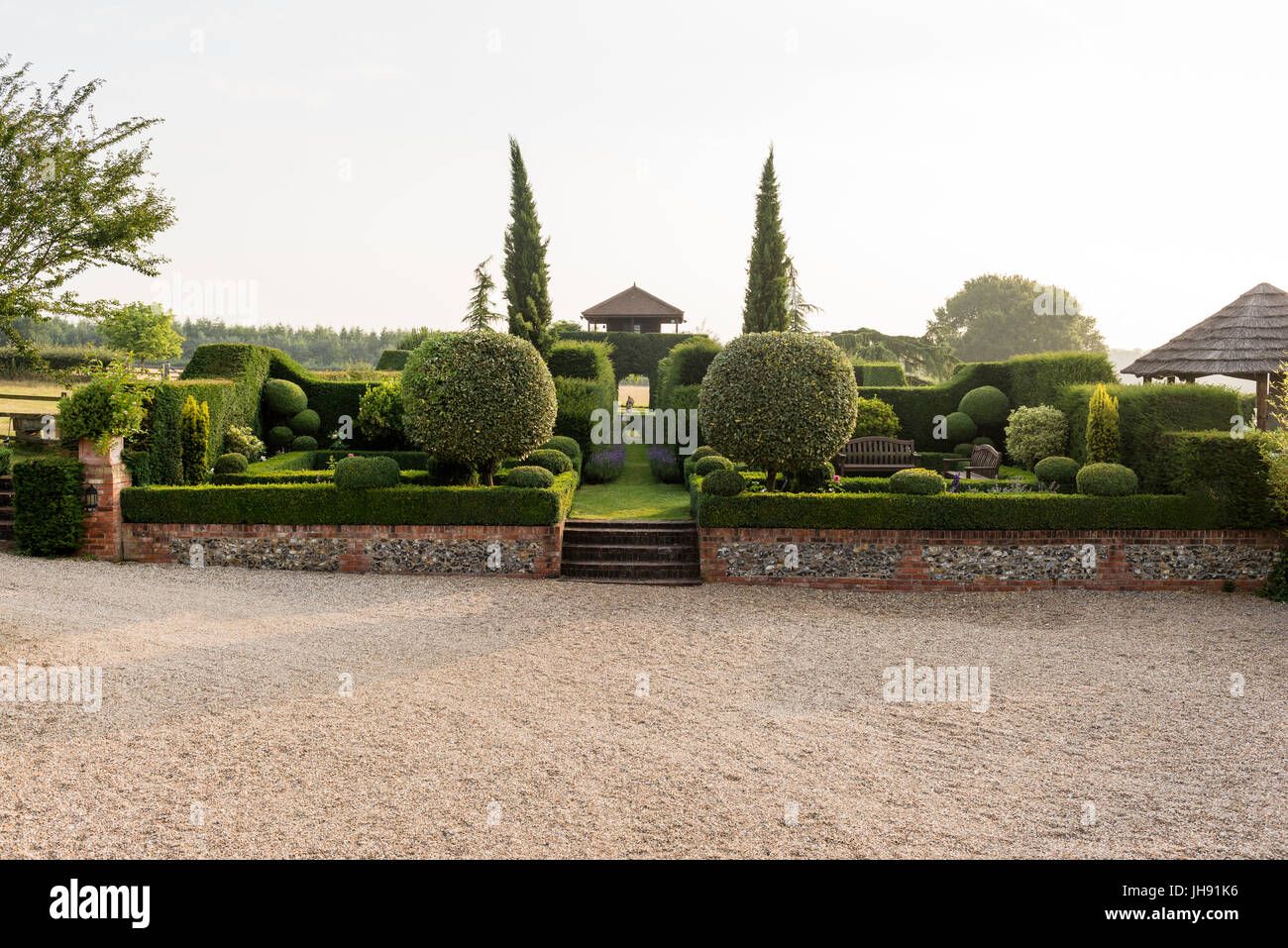Muro di mattoni e scale in hedge garden Foto Stock