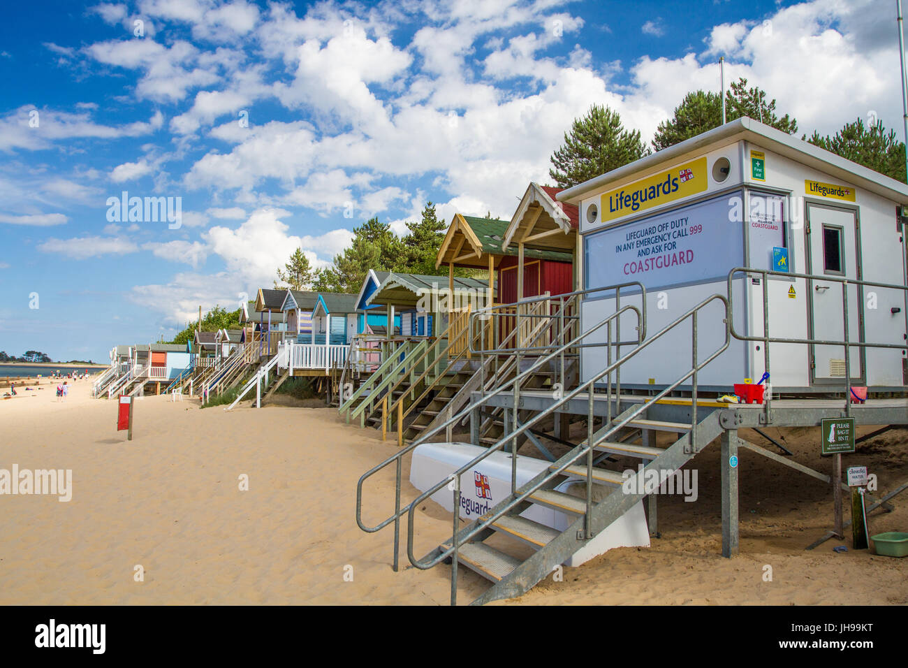 Un HM stazione di guardia costiera e file di cabine sulla spiaggia, su una spiaggia di sabbia in Norfolk, Regno Unito che è chiusa in rappresentanza di una spiaggia che non è sorvegliato da bagnini. Foto Stock