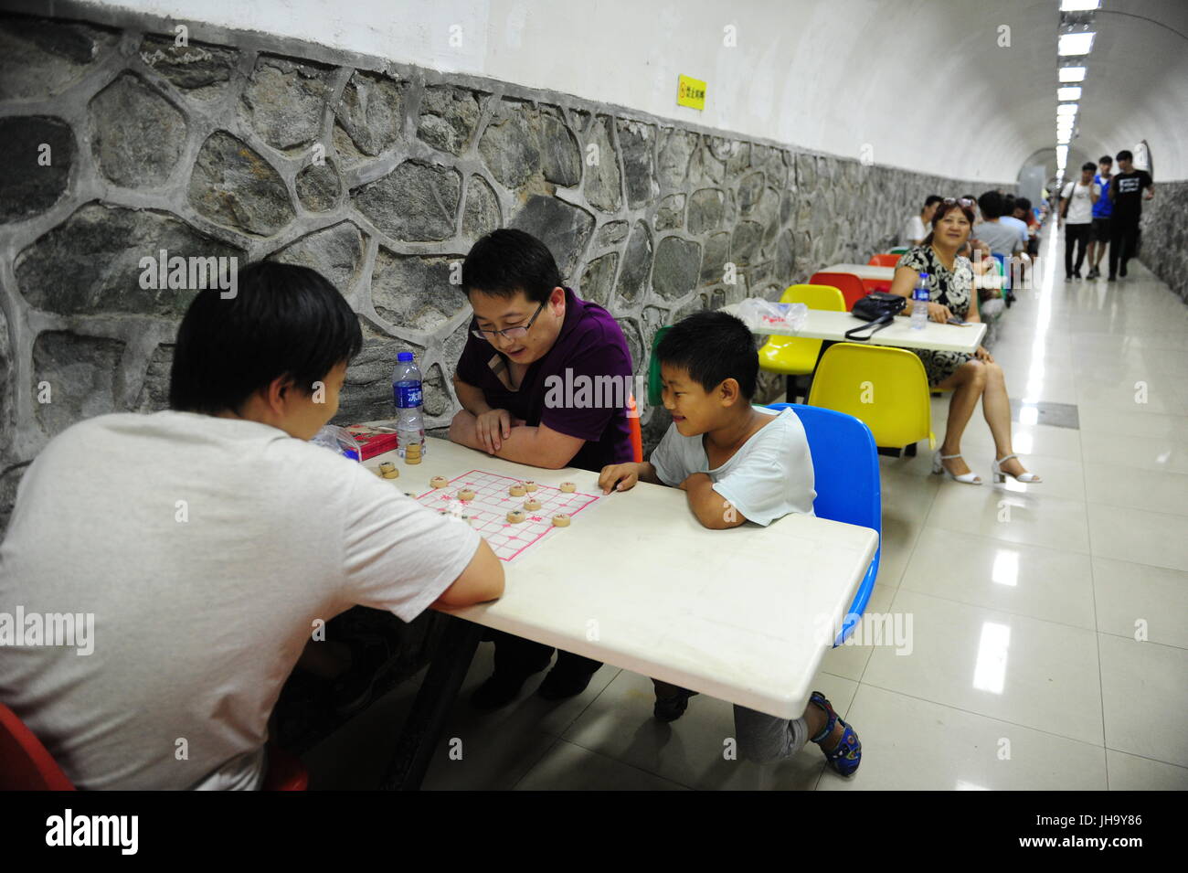 Xi'an, la Cina della provincia di Shaanxi. 13 Luglio, 2017. Cittadini scacchi cinesi in uno spazio sotterraneo per la frescura di Xi'an, capitale della Cina nord-occidentale della provincia di Shaanxi, 13 luglio 2017. Un rosso segnale warning per il calore è stato rilasciato a 9:20 a.m.dall'Osservatorio metrologico di Xi'an giovedì, e si aspetta che la temperatura massima della maggior parte delle aree in Xi'an per essere al di sopra dei 40 gradi Celsius. Credito: Zhang Bowen/Xinhua/Alamy Live News Foto Stock
