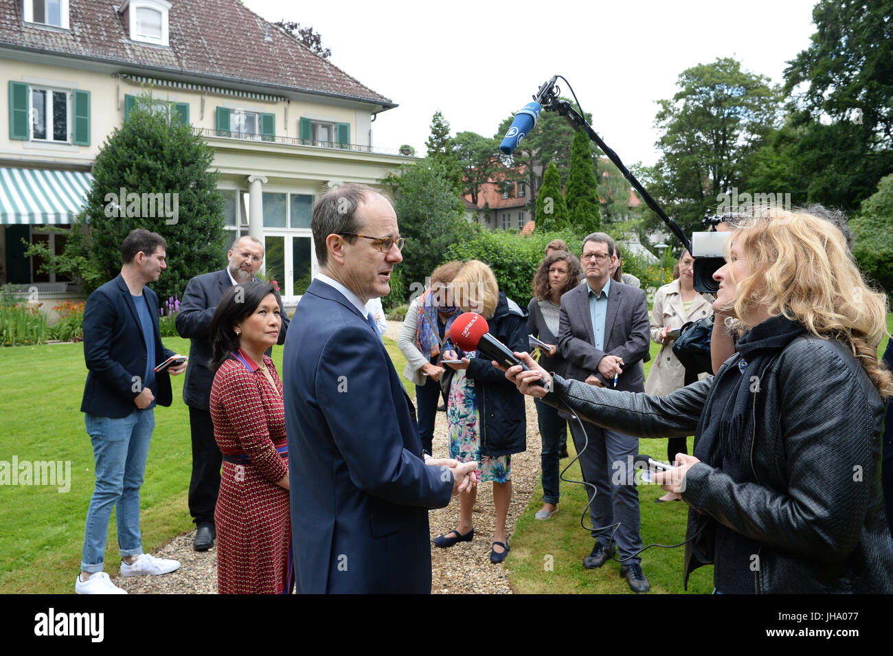 Berlino, Germania. 13 Luglio, 2017. Ambasciatore britannico in Germania Sir Sebastian di legno e di sua moglie Lady Sirinat arrivano in legno con il loro cane Albie per scattare una foto al giardino della residenza dell'Ambasciatore britannico a Berlino, Germania, 13 luglio 2017. Quesiti hanno ricevuto risposta per quanto riguarda la regina della festa di compleanno, che si svolgerà il 19 luglio con la presenza di il Duca e la Duchessa di Cambridge. La Gran Bretagna è il principe Willian e il suo wiffe arriva a Berlino il 19 luglio. Foto: Jens Kalaene/dpa-Zentralbild/dpa/Alamy Live News Foto Stock