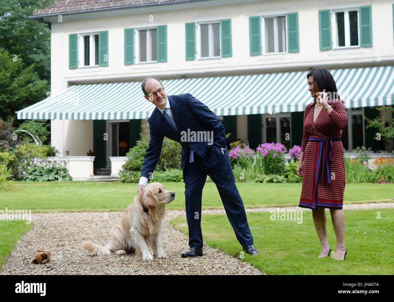 Berlino, Germania. 13 Luglio, 2017. Ambasciatore britannico in Germania Sir Sebastian di legno e di sua moglie Lady Sirinat arrivano in legno con il loro cane Albie per scattare una foto al giardino della residenza dell'Ambasciatore britannico a Berlino, Germania, 13 luglio 2017. Quesiti hanno ricevuto risposta per quanto riguarda la regina della festa di compleanno, che si svolgerà il 19 luglio con la presenza di il Duca e la Duchessa di Cambridge. La Gran Bretagna è il principe Willian e il suo wiffe arriva a Berlino il 19 luglio. Foto: Jens Kalaene/dpa-Zentralbild/dpa/Alamy Live News Foto Stock