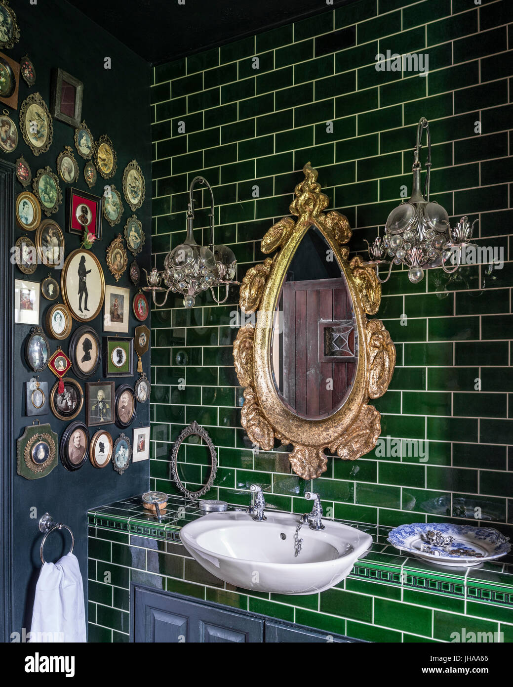 Specchio d'oro su lavandino con piastrelle verdi Foto Stock