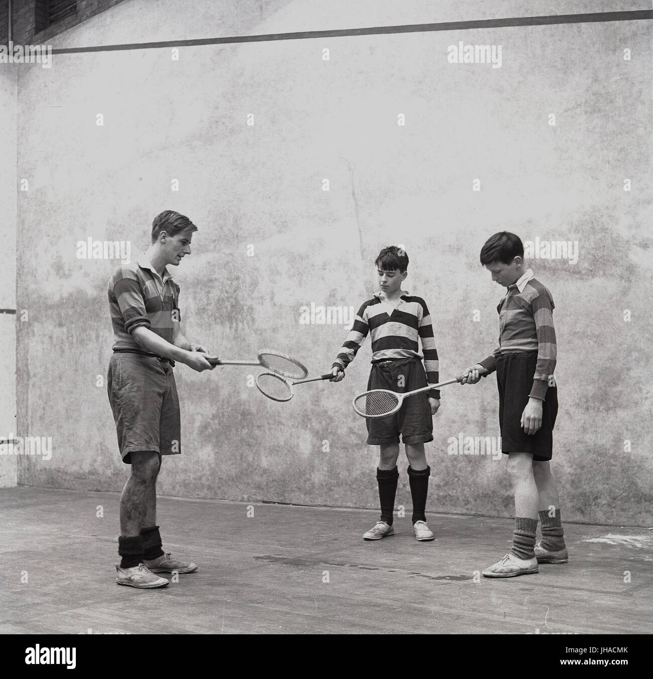 1948, due ragazzi a Haileybury College, un pubblico britannico scuola, interno su un campo da squash haviing una lezione da un insegnante o un pullman su come giocare il gioco di racchette o squash, Hertford, Inghilterra, Regno Unito. Foto Stock