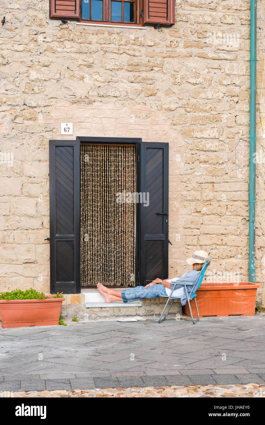 Donna vacanza dormire, una donna di mezza età prende un pisolino fuori la sua casa vacanze ad Alghero in Sardegna. Foto Stock