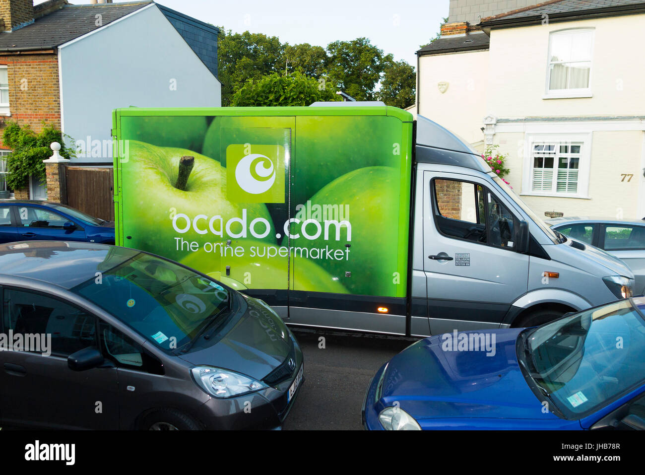 Ocado / Ocado.com supermercato / super mercato furgone in una strada residenziale o strada facendo home delivery & bloccando il flusso del traffico. Regno Unito Foto Stock