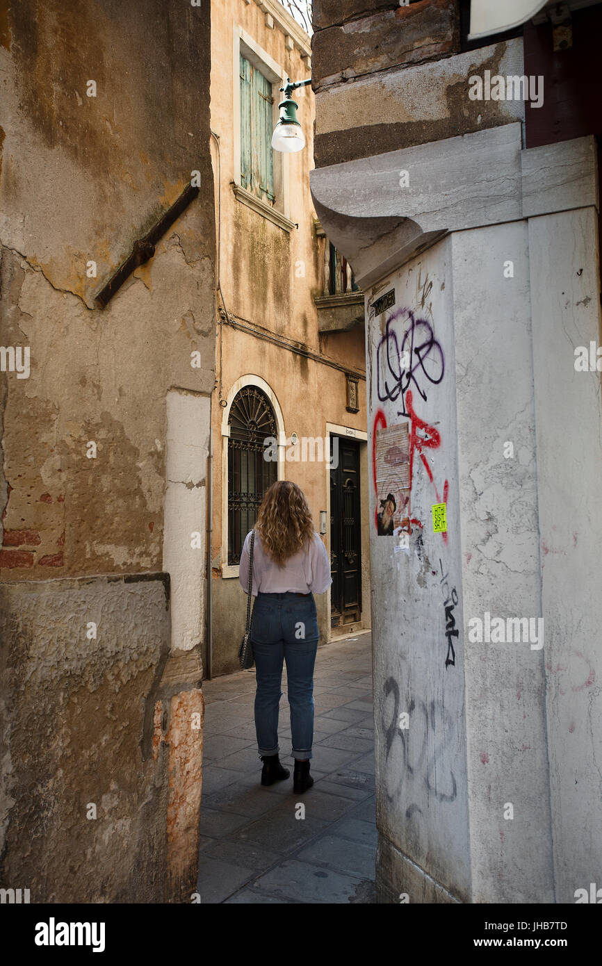 Un giovane, Bionda, bella milennial esplorare e vagare per le strade di Venezia, Italia e Europa in estate. Un famoso storico di destinazione di viaggio Foto Stock
