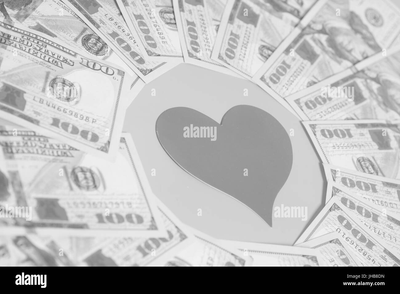 Cuore di carta e centinaia di fatture del dollaro per lo sfondo Foto Stock
