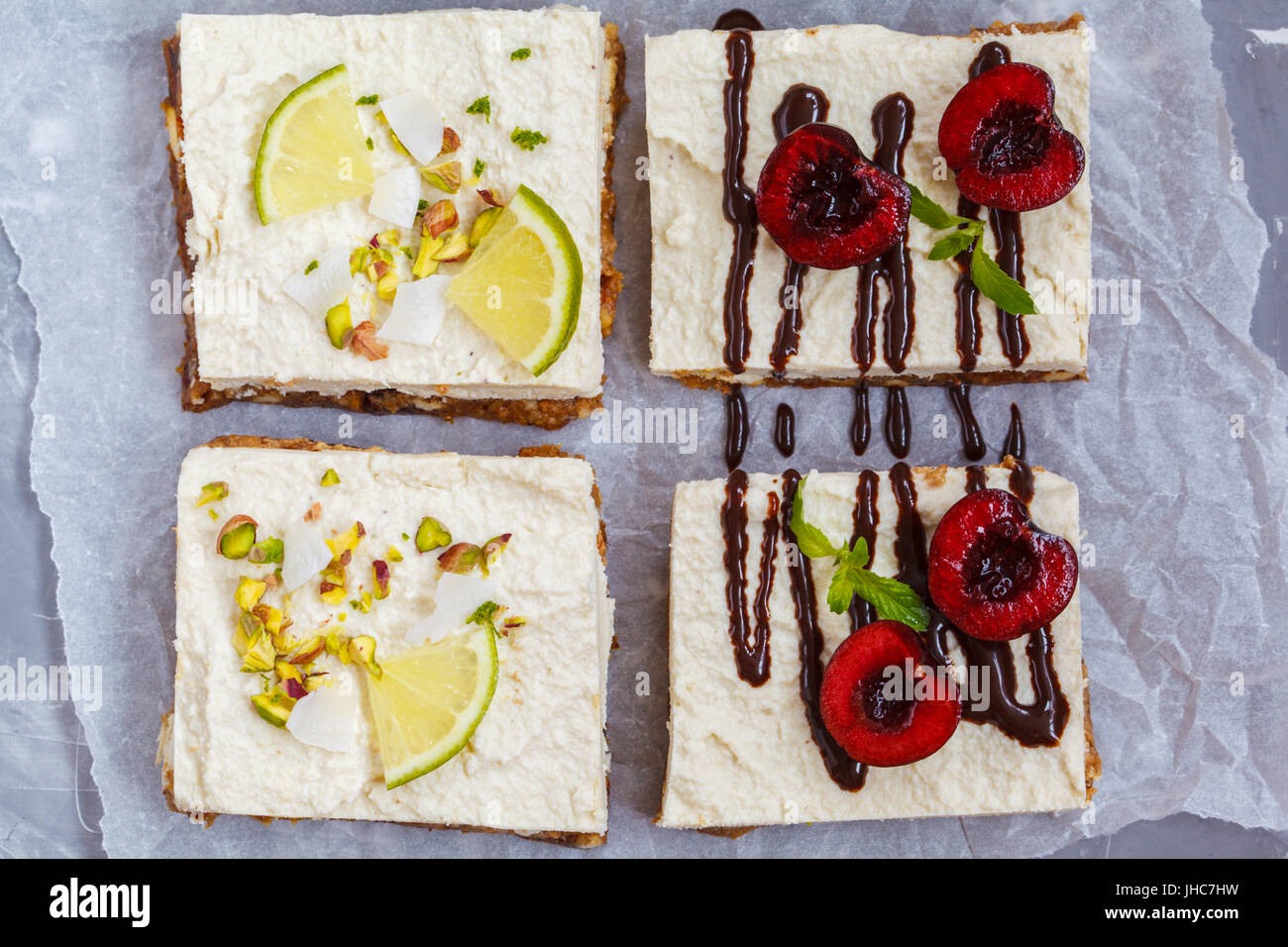 Materie di pistacchio, noci di cocco, calce e il cioccolato-cherry cheesecake. Amore per un sano cibo vegan concetto. Foto Stock