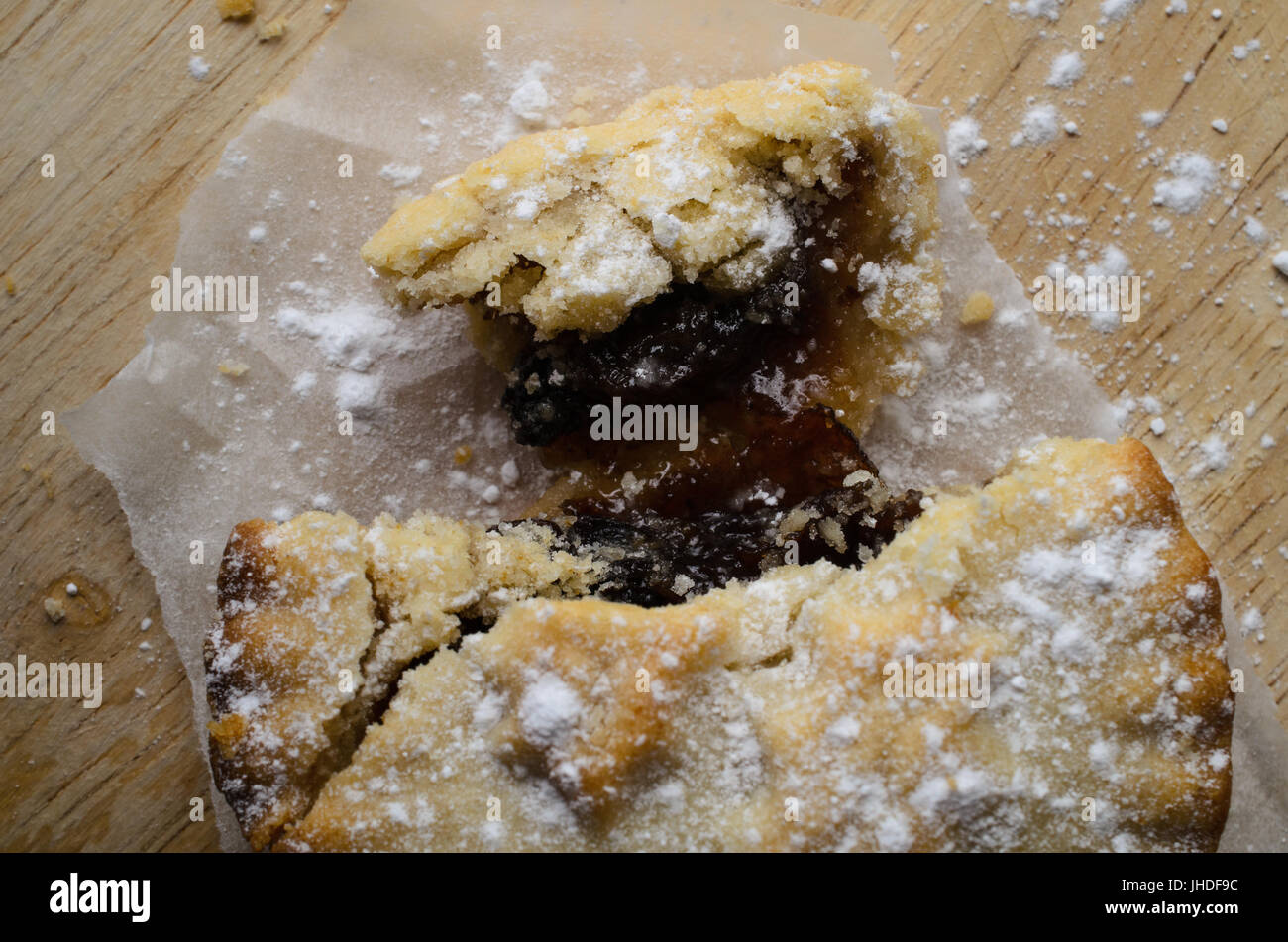 Tettuccio di close up di tritare la torta, rotte aperte come se parzialmente consumato, con ripieno di frutta esposta e la pasticceria briciole sparse. Foto Stock