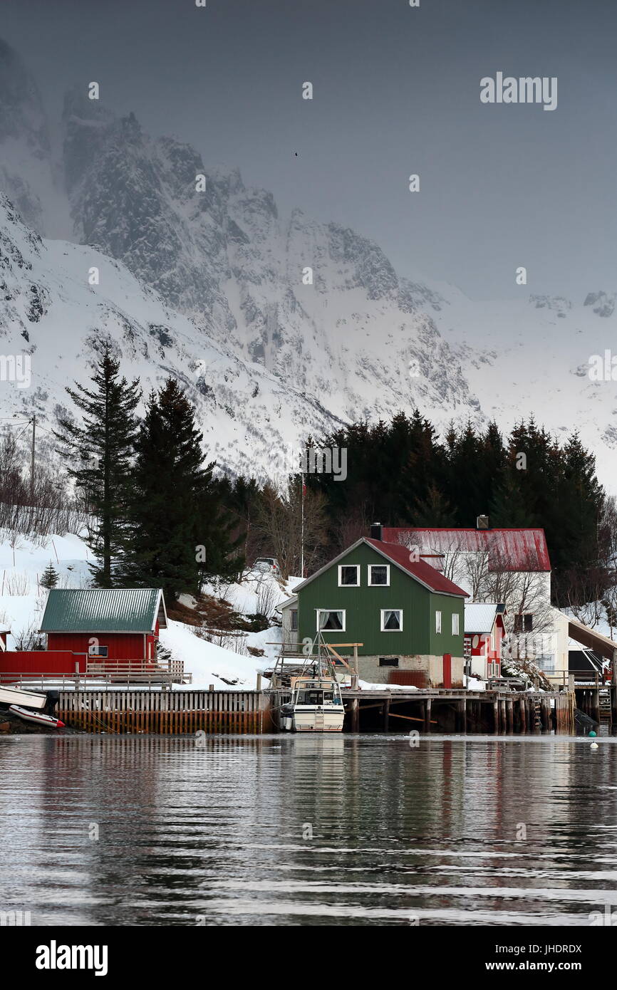 Rosso-verde-bianco cottages con la lamiera del tetto e parete in villaggio Vestpollen oltre Austnesfjorden-Austvagoya isola. Kistberget-Glamen-Dalhaugmarka mo Foto Stock