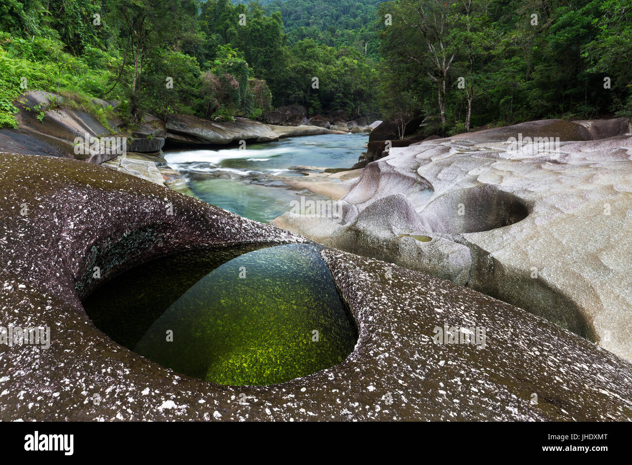 Una chiara emerald pool in rocce di granito su un fiume orlato da una lussureggiante foresta pluviale tropicale. Foto Stock