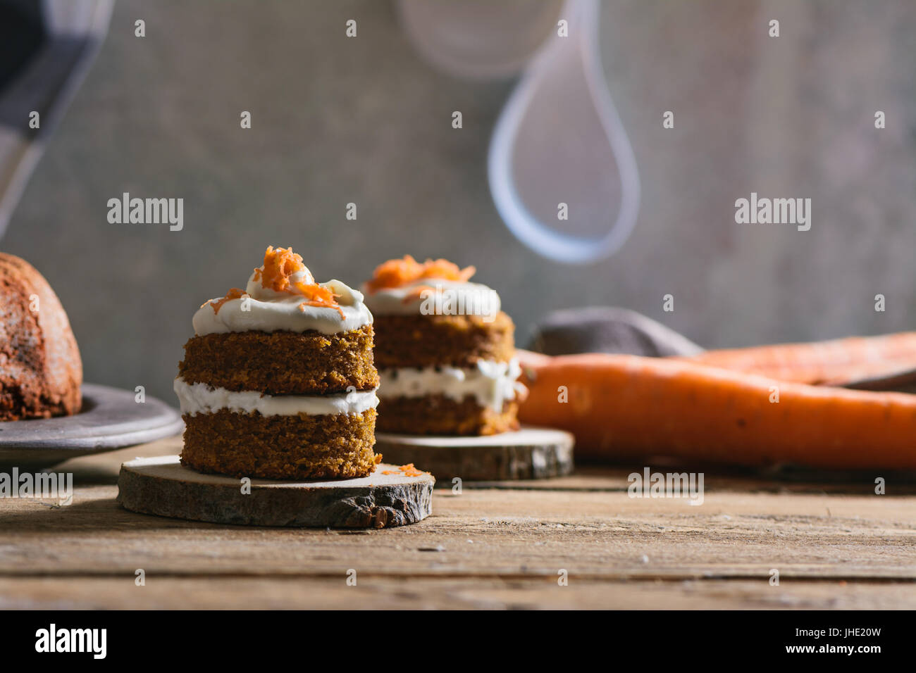 Mini torta di carote, farcito con crema di formaggio, sul legno rustico piastra, close up Foto Stock