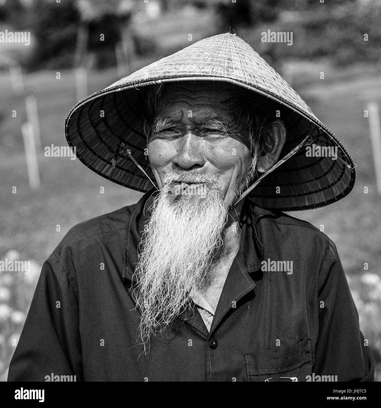 Barbuto vecchio uomo del Vietnam in un cappello conico - bianco e nero Foto Stock