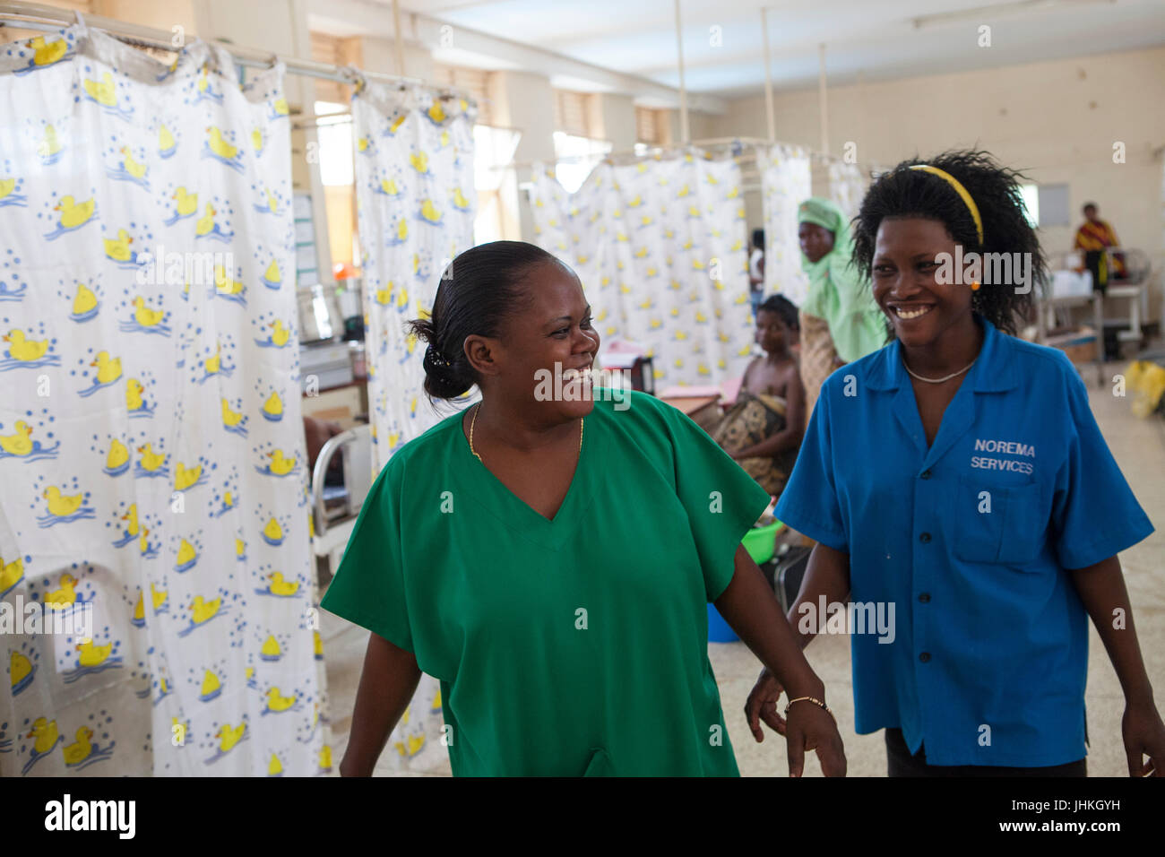 Un infermiere e una levatrice il sorriso a ogni altro durante un turno di occupato sul reparto di maternità in Ospedale Mulago, Uganda. Foto Stock