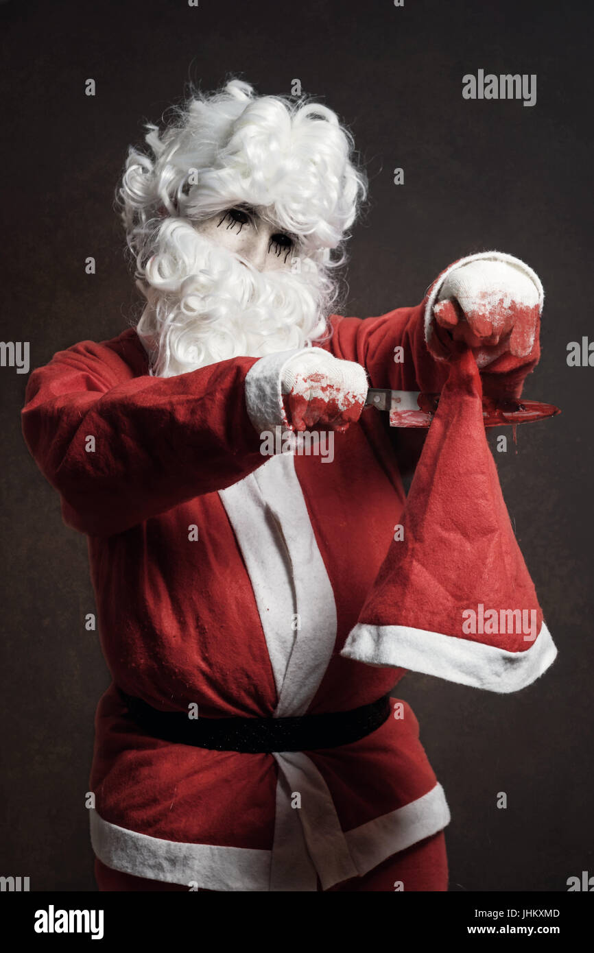 Il male di Santa Claus tagliati con il coltello insanguinato il suo cappello di Natale Foto Stock