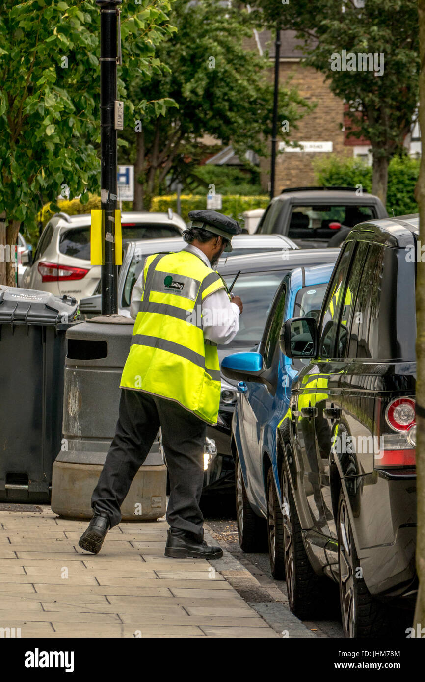 Un London Borough of Ealing vigile circa il rilascio di un ticket. Londra, Inghilterra, Regno Unito. Foto Stock