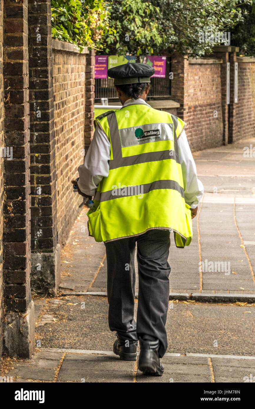 Un London Borough of Ealing vigile camminando giù un Ealing, London street, Inghilterra, Regno Unito. Foto Stock