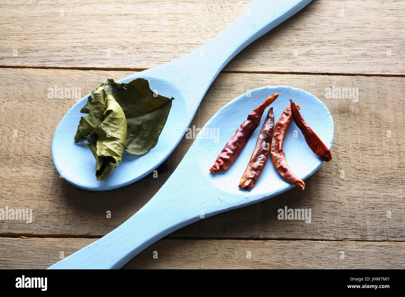 Curry ingredienti su cucchiai con sfondo di legno Foto Stock