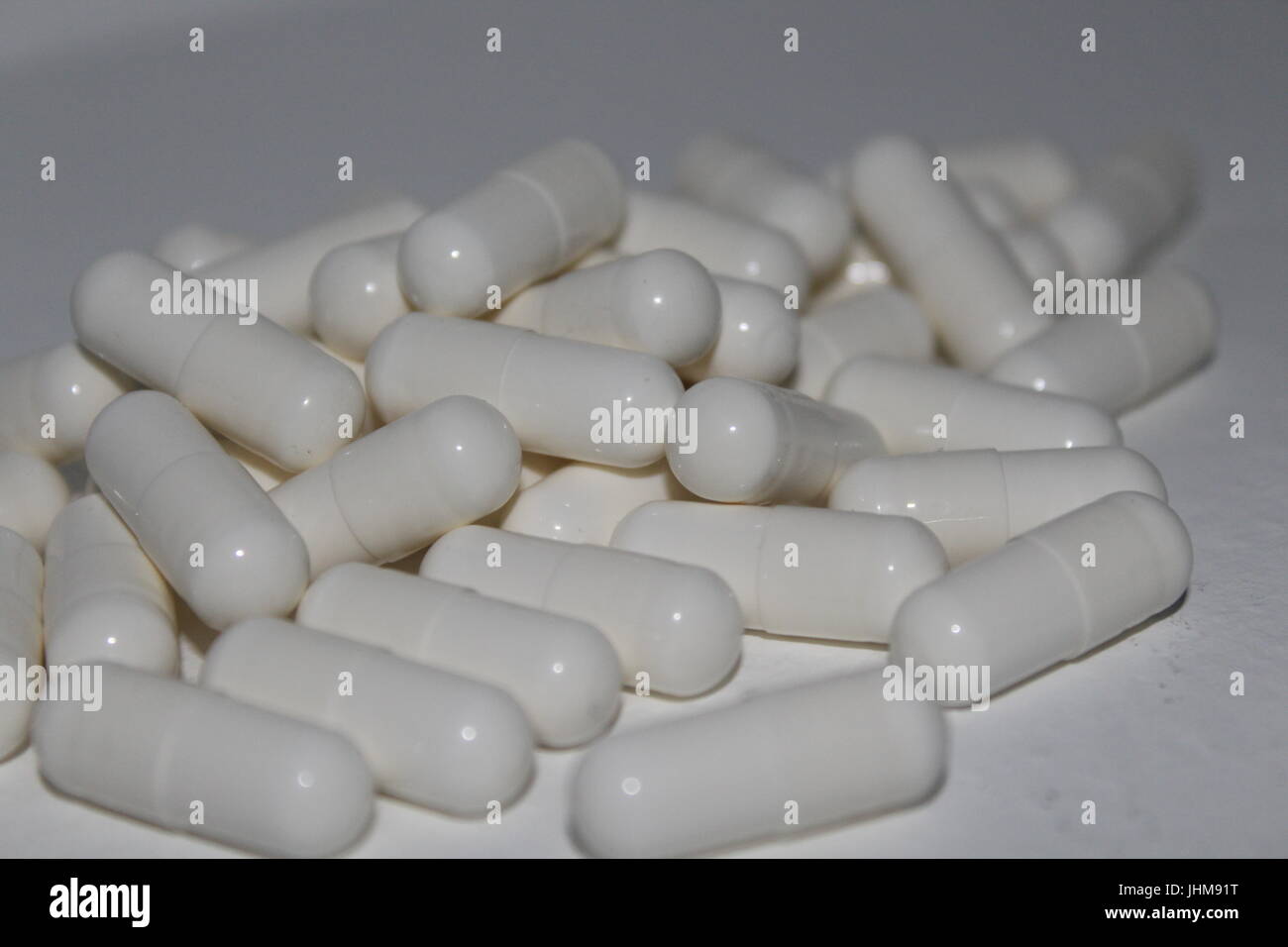 Pila di pillole di bianco su sfondo bianco Foto Stock