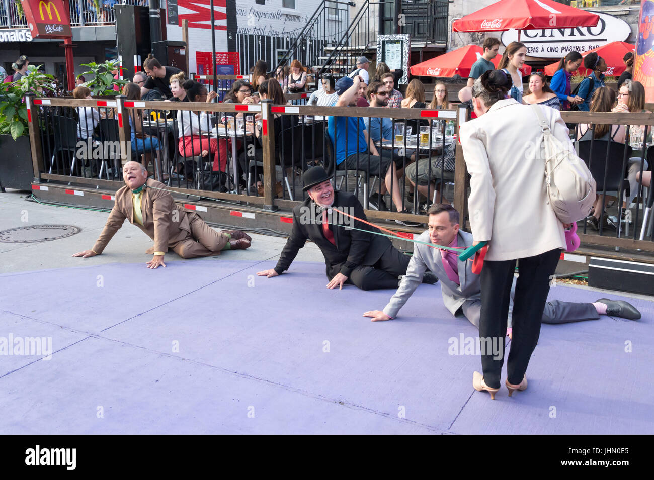 Montreal, Canada - 13 Luglio 2017: Donna camminare tre uomini sul cane guinzagli di Montreal durante il Festival Del Circo Foto Stock