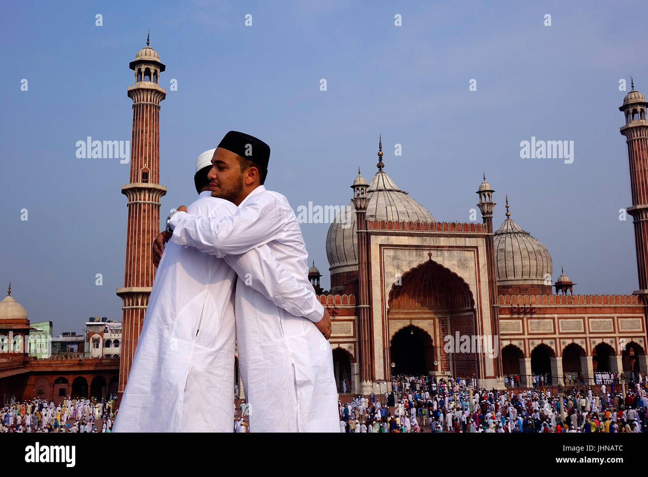 Due uomini musulmani con happy smile celebrare la festa islamica eid ul fitr il festival di amore e di gioia e che desiderano abbracciando gli uni agli altri Foto Stock