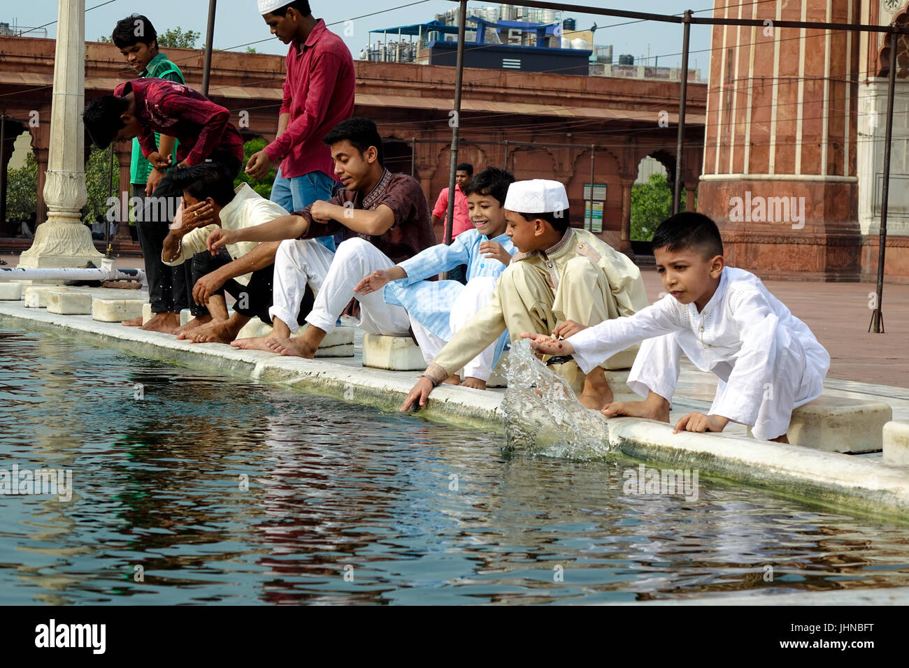 Bambini che giocano in abluzione stagno in Jama Masjid sul margine del l'Eid Al Fitr e festeggiare. Foto Stock
