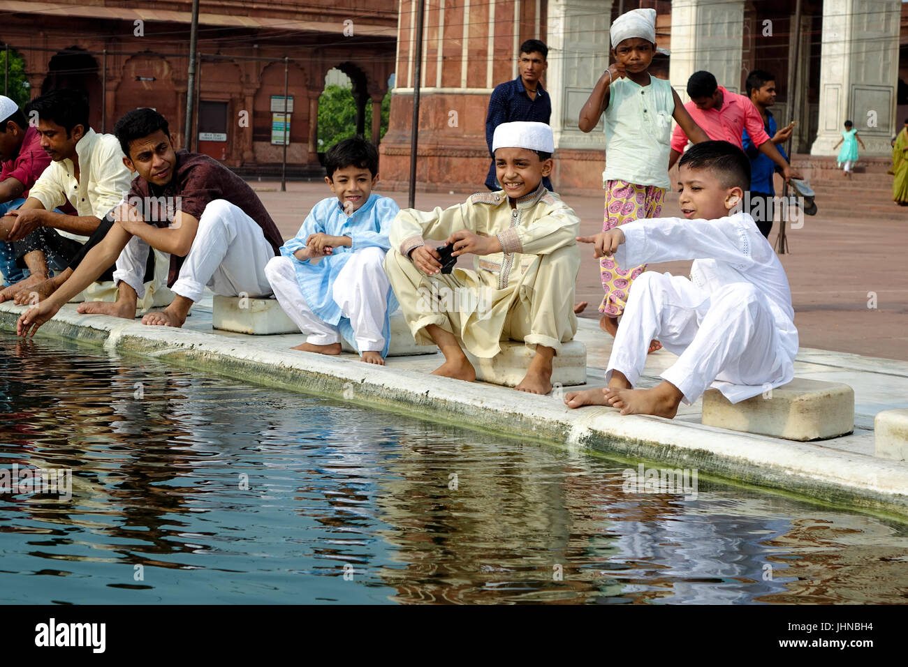 Bambini che giocano in abluzione stagno in Jama Masjid sul margine del l'Eid Al Fitr e festeggiare. Foto Stock